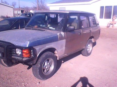 1991 Land Rover Range Rover - A 1991 Land Rover Range Rover is seen from a three-quarter front angle, showing its distinctive body style.