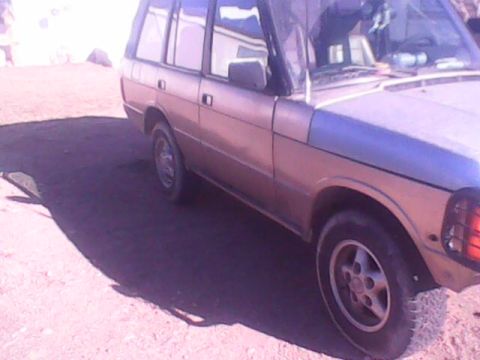 1991 Land Rover Range Rover - Side view of a 1991 Land Rover Range Rover parked outdoors on a dirt surface.