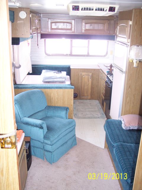 1973 Ford F-250 - The interior of a recreational vehicle shows a living area with seating, a kitchen, and sleeping accommodations.