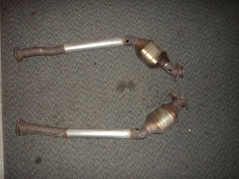 2004 Mercury Grand Marquis - Two exhaust catalytic converters are shown laid out on a carpeted surface.