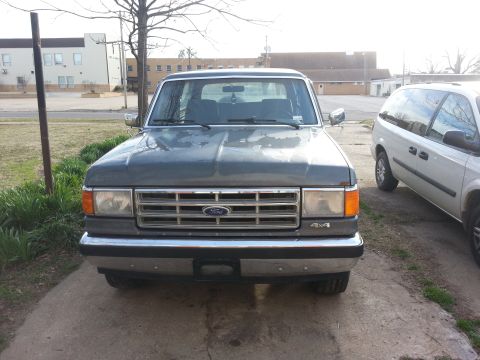1987 Ford Bronco - This 1987 Ford Bronco is shown from the front, parked next to a white minivan.
