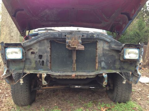 1979 Ford Bronco - The front of a truck is shown with the hood up and missing some body panels and the grille.
