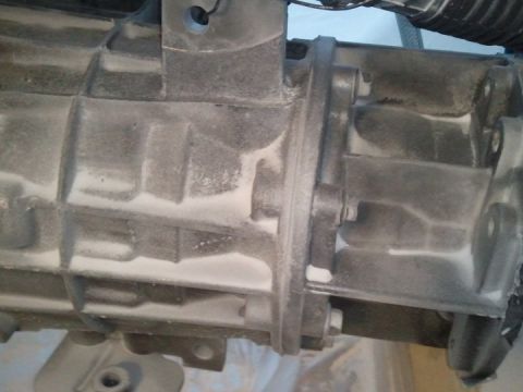 1994 Ford Bronco - Transmission housing detail, likely from an older vehicle, covered in dust.