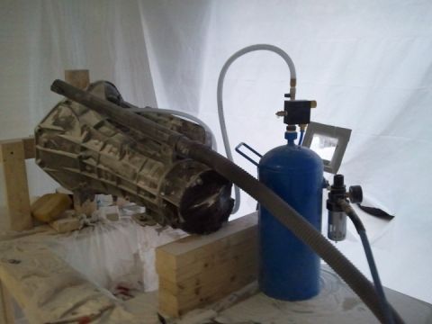1994 Ford Bronco - A transmission is set up with a sandblaster for cleaning or restoration.