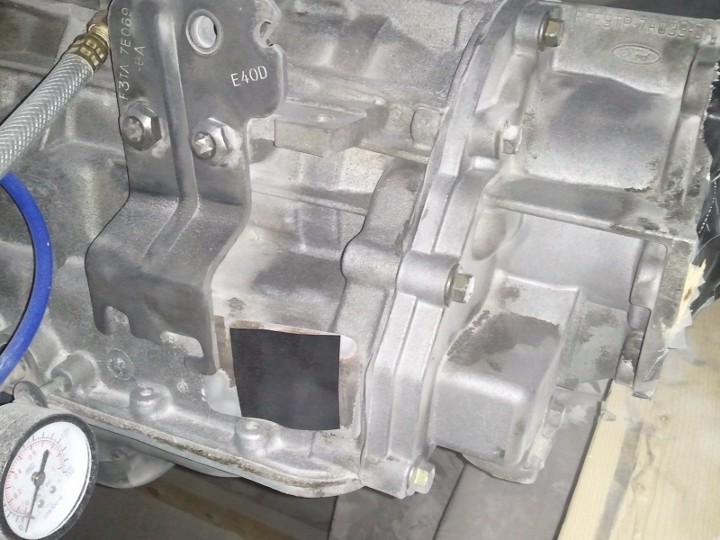 Transmission housing with a gauge and blue hose attached