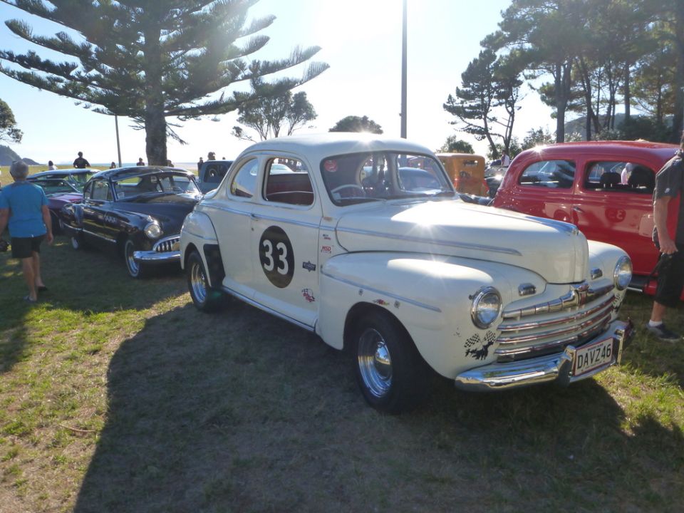 Cream 1946 Ford coupe with black circle and number 33 on door, racing decals, and license plate DAV246