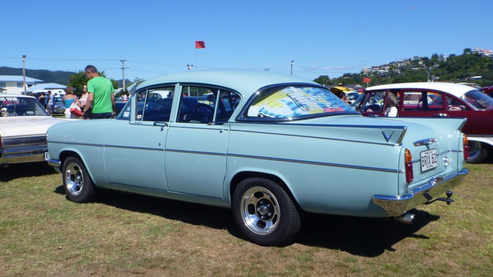 Light blue sedan rear view with chrome trim and custom wheels