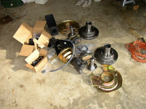 1995 Ford Bronco - Various automotive brake and hub components are laid out on a concrete surface.