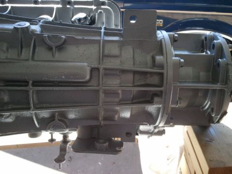 1994 Ford Bronco - A close-up view of a vehicle's transmission, with a portion of the vehicle's body visible in the background.