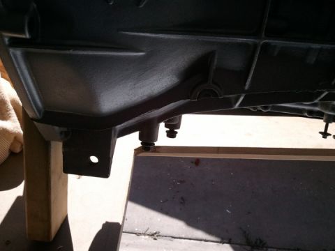 1994 Ford Bronco - Close-up view of a dark-colored transmission housing, possibly undergoing maintenance or repair.
