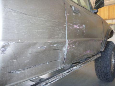 1997 Ford Ranger - This truck's side panel and door show significant damage, including dents and numerous scratches.