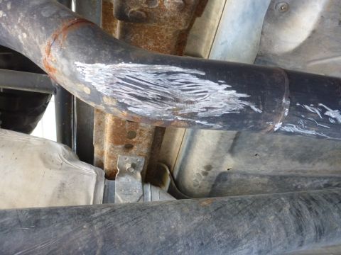 1997 Ford Ranger - Scraped exhaust pipe and rusty undercarriage components are visible in this close-up view.