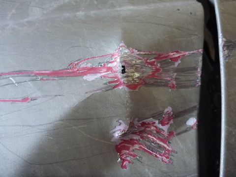 1997 Ford Ranger - This image shows significant damage to a vehicle's body panel, with scraped paint revealing underlying metal.