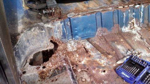 1979 Ford Bronco - Severe rust damage is visible on the vehicle's floor pan, indicating extensive corrosion.