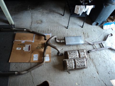 2004 Mercury Grand Marquis - Various exhaust system components, including mufflers and pipes, are arranged on a concrete surface.