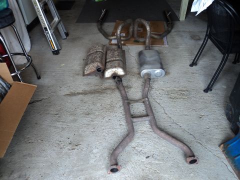 2004 Mercury Grand Marquis - Exhaust system components, likely from a car, are shown disassembled on the ground.