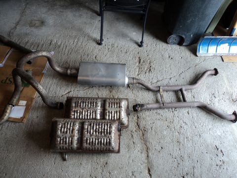 2004 Mercury Grand Marquis - Several exhaust system components, including mufflers and pipes, are arranged on a concrete surface.