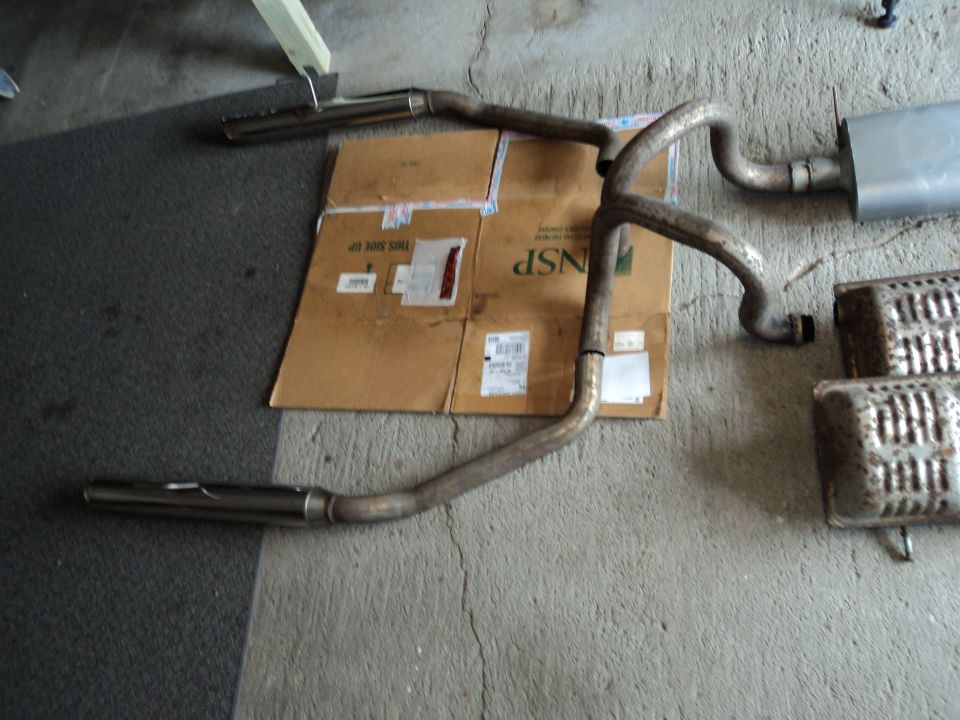 Exhaust pipes and mufflers on concrete floor with cardboard box
