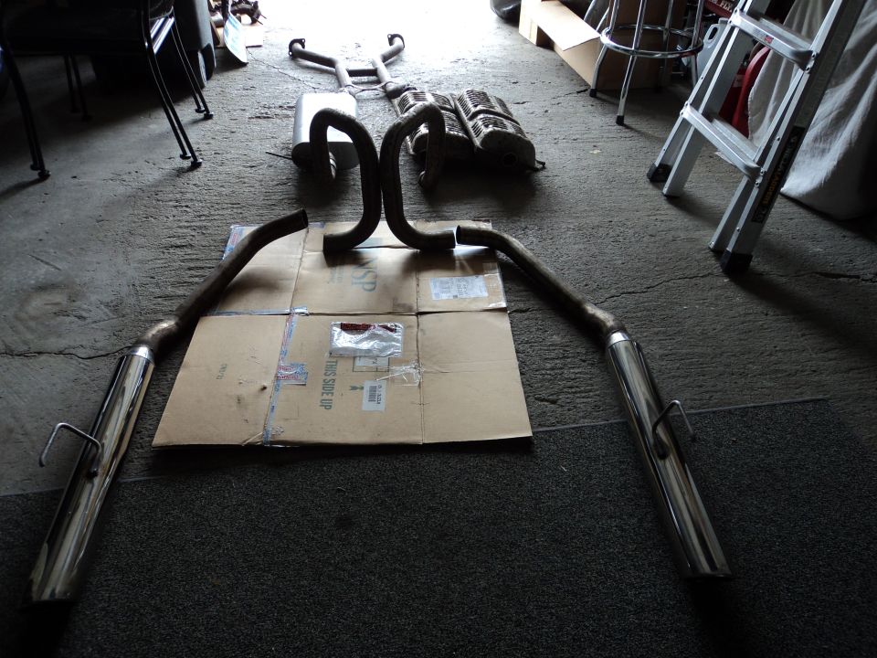 Exhaust system parts laid out on cardboard