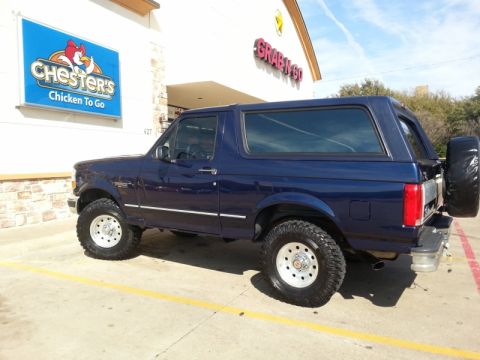1995 Ford Bronco - A blue Ford Bronco is parked in a lot outside a Chester's Chicken To Go restaurant.