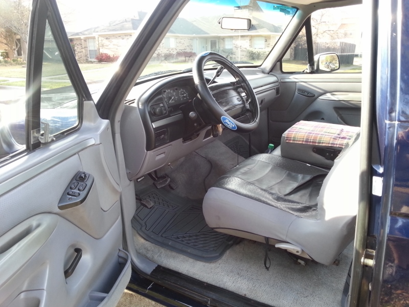 Interior of a blue Ford truck showing the dashboard, steering wheel, and driver's seat