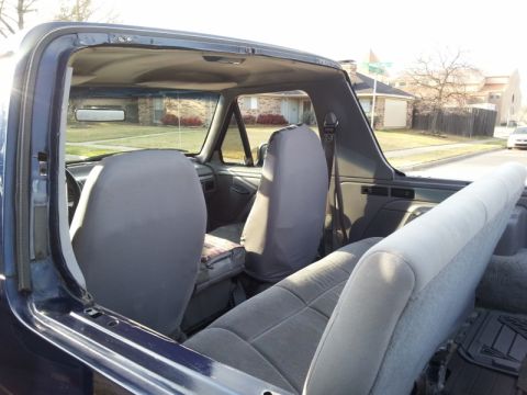 1995 Ford Bronco - The interior of a blue 1995 Ford Bronco is visible with the removable top section taken off.