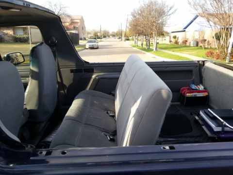 1995 Ford Bronco - Interior view of a 1995 Ford Bronco, looking towards the street from the back seat.