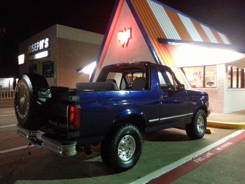 Blue 1995 Ford Bronco parked at night