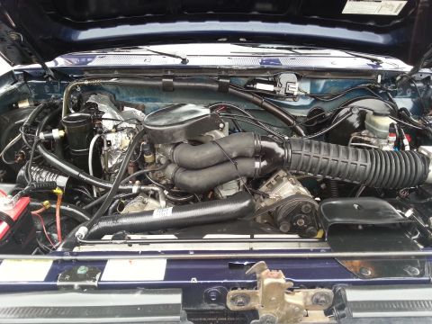 1995 Ford Bronco - The engine bay of a 1995 Ford Bronco, showing the V8 engine and associated components.