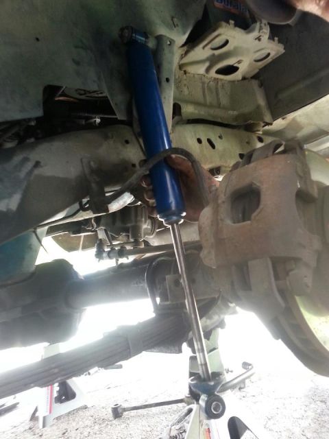 1982 Jeep Wagoneer - Working on the suspension system of a vehicle, focusing on the shock absorber replacement.