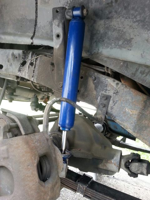 1982 Jeep Wagoneer - Close-up view of a blue shock absorber mounted on the suspension of a vehicle.