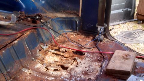 1979 Ford Bronco - The interior floor of this vehicle shows significant rust and damage, with exposed wiring visible.