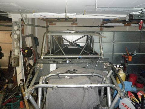 1961 International Scout 800 - Custom roll cage and chassis are visible in a garage setting. The vehicle appears to be under construction.