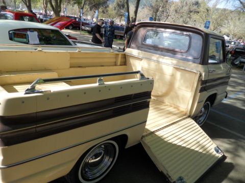 1973 Ford Ranchero - A vintage pickup truck, likely a 1961 Chevrolet Corvair Rampside, is displayed with its tailgate open at a car show.