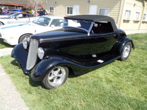 1973 Ford Ranchero - Black 1933 Ford hot rod convertible with a black top is parked on grass at an outdoor event.