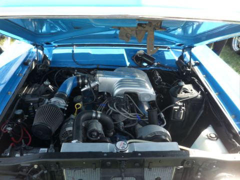 1973 Ford Ranchero - The engine bay of a car is shown with the hood open, revealing the engine components.