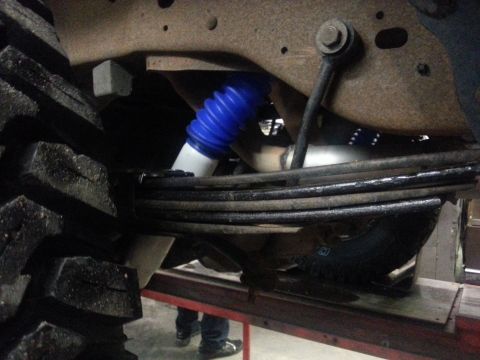 1995 Ford Bronco - Undercarriage view of a vehicle's suspension system, focusing on the tire and shock absorber.