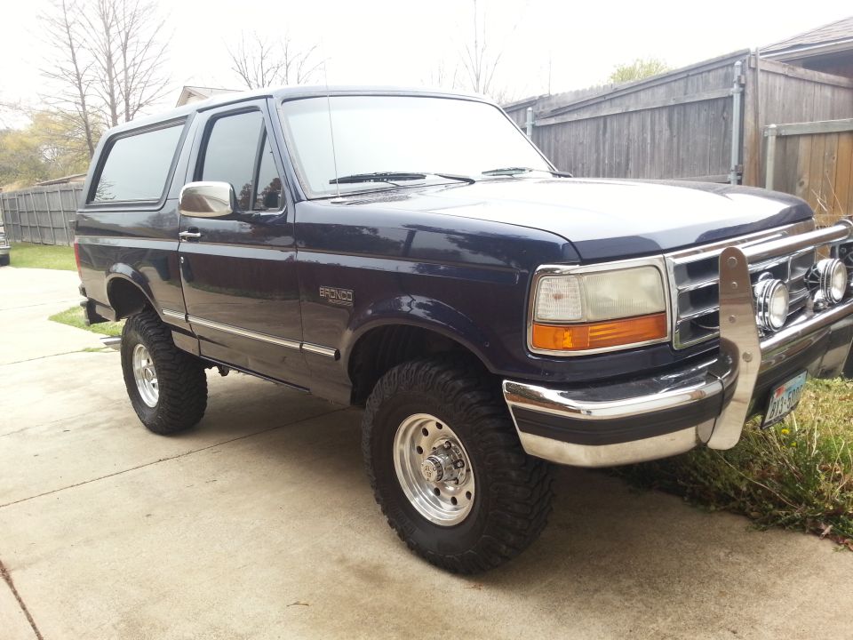 Dark blue 1995 Ford Bronco with chrome grille guard and aftermarket wheels