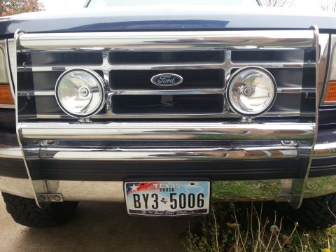 1995 Ford Bronco - Front view of a dark blue Ford Bronco with a chrome bull bar and fog lights, displaying a Texas license plate.