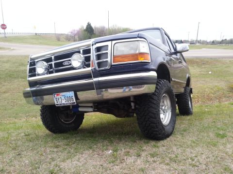 1995 Ford Bronco - This lifted Ford Bronco features a chrome grille and large off-road tires.