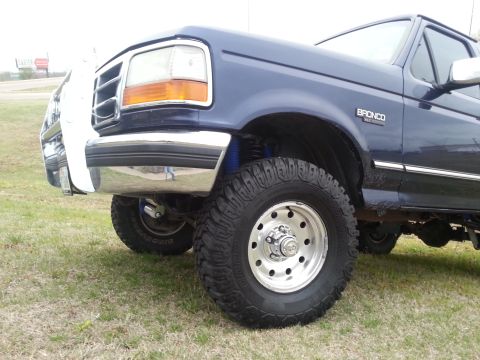 1995 Ford Bronco - Close-up of a 1995 Ford Bronco's front fender, showing the wheel and tire.