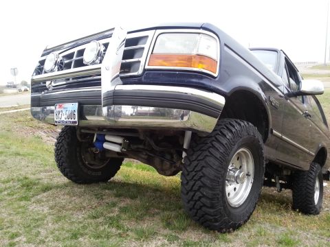 1995 Ford Bronco - This lifted 1995 Ford Bronco features a chrome brush guard and large off-road tires.