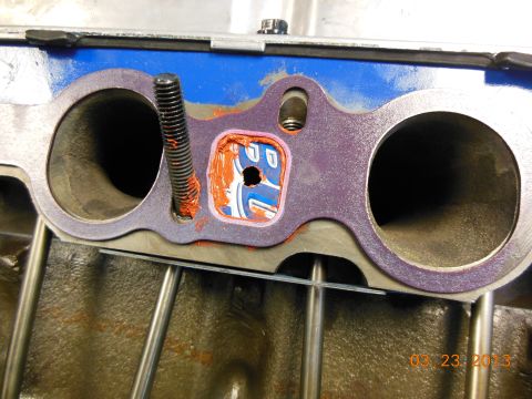 1979 Ford F-150 - Close-up of an engine manifold gasket with sealant and a bolt, showing visible text from a website.
