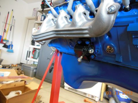 1979 Ford F-150 - Close-up of a blue engine block with silver intake manifold, mounted on a red engine stand.