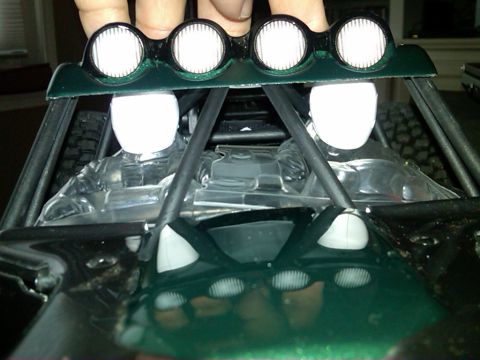 1986 Ford Bronco - Interior view of a green off-road vehicle, a roll cage and four roof-mounted spotlights.