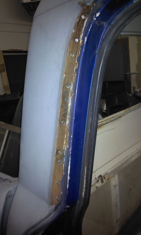 1967 Ford F-100 - Close-up of a 1967 Ford F-100 door frame showing rust along the seam and blue paint.