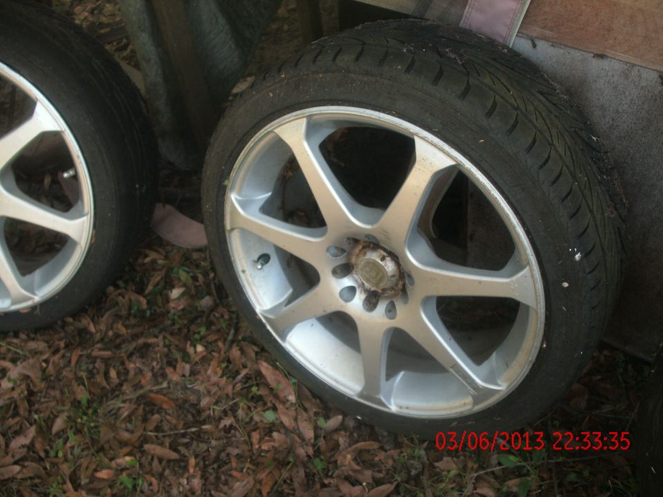 two alloy wheels with tires on the ground
