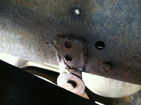 1996 Ford Bronco - Close-up of rusted vehicle frame with a mounting bracket and bolt visible.