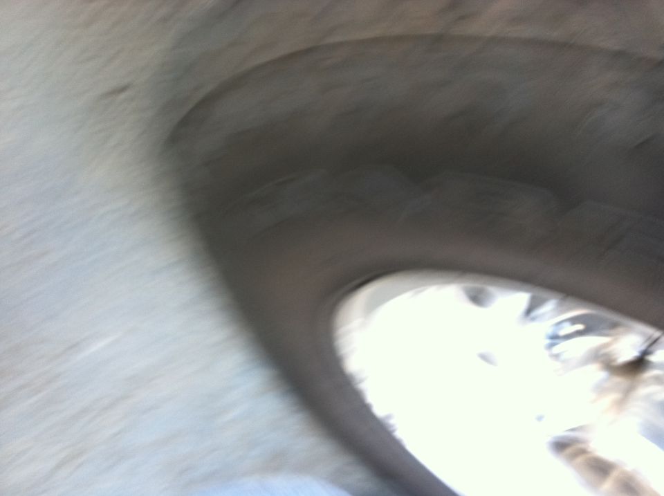 Close-up of a wheel well with a tire visible through the opening. Supermotors.net logo in the corner