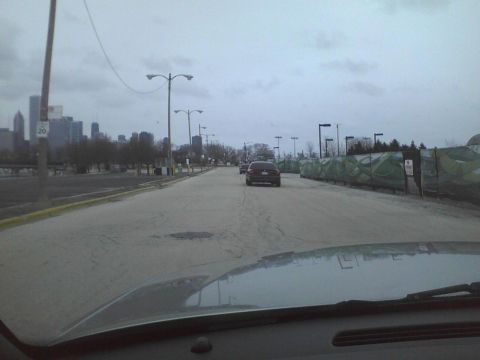 2003 Ford Crown Victoria - Driving on a road with a city skyline in the distance and other vehicles ahead.